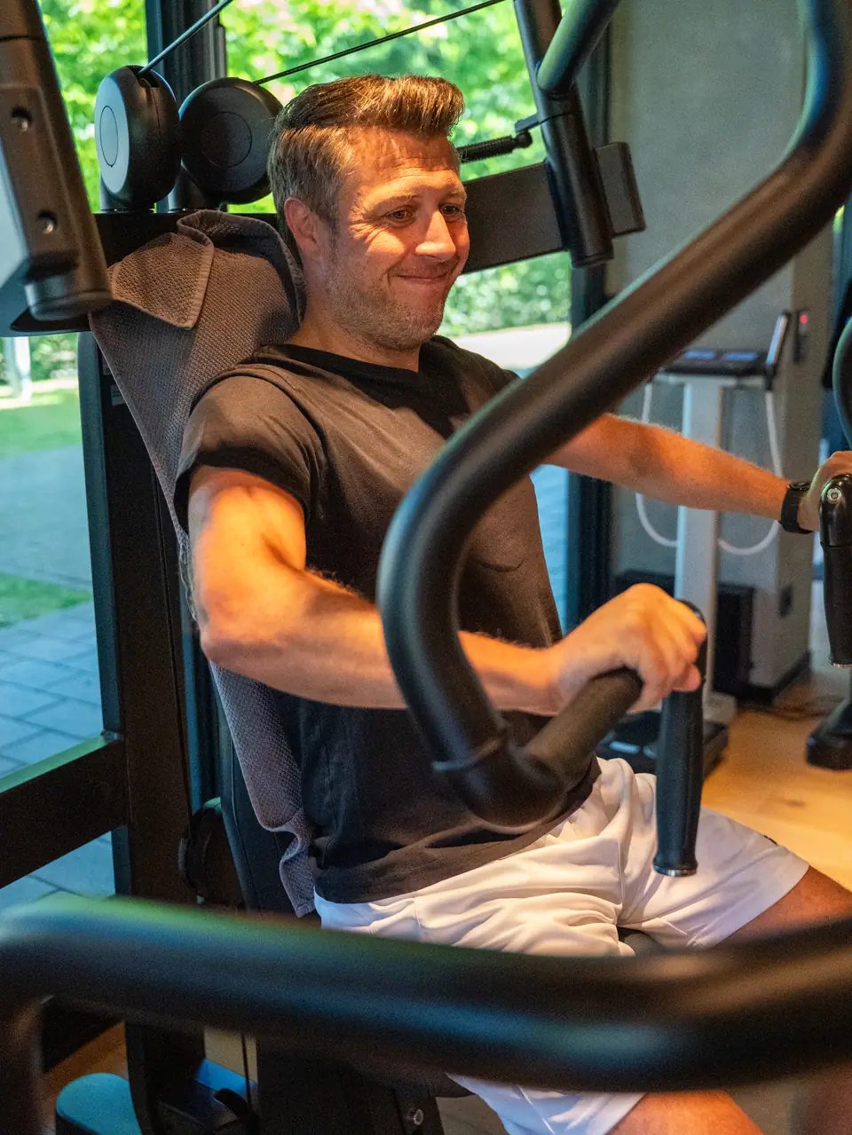 Gut gelauntes Mitglied an der Brustpresse bei CIRCLEONE